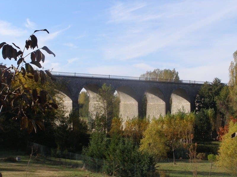 Le viaduc de Bajamont entre les arbres en automne